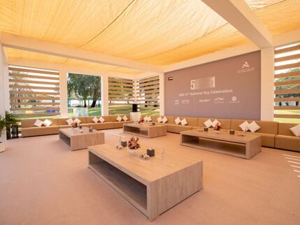 A modern Majlis with taupe, wood and beige elements and bright sunlight